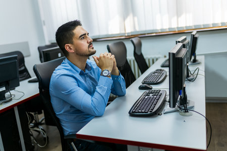 Male student using desktop PC in computer lab.の写真素材