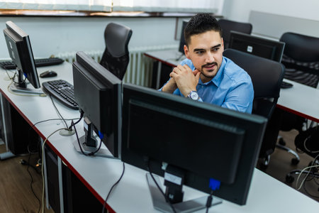 Male student using desktop PC in computer lab.