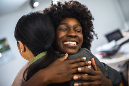 Multiethnic group of coworkers hugging at a group therapy session, overcoming problem together.の写真素材
