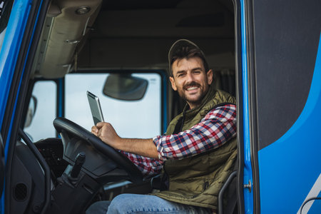 Happy confident male driver sitting in  his truck, using his tabletの写真素材