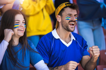 Football / soccer fans are cheering for their team at the stadium on the matchの写真素材