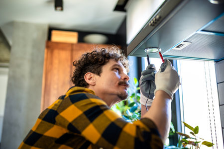 Latino man fixing aspirator in the kitchen.の写真素材
