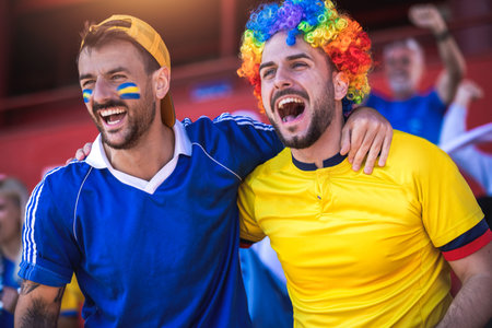 Football / soccer fans are cheering for their team at the stadium on the matchの写真素材