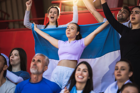 Football / soccer fans are cheering for their team at the stadium on the matchの写真素材