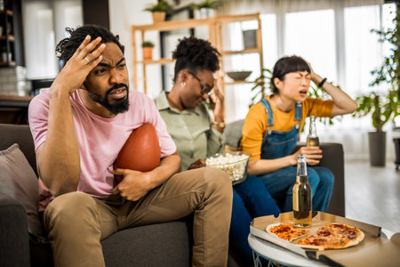 Multiracial group of friends watching rugby. Angry because their team is losing.の写真素材