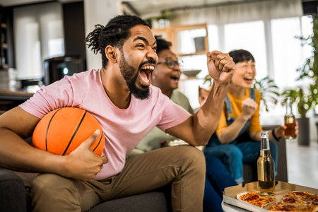 Multiracial group of friends watching basketball game, eating pizza, drinking beer and cheering.の写真素材