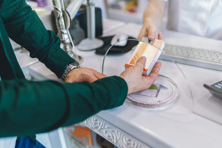 Woman, pharmacist consulting father and son at counter for prescription drugs or medicine at the...