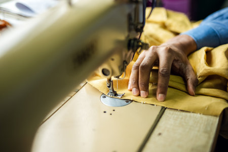 African American man fashion designer sewing on a vintage sewing machine.の写真素材