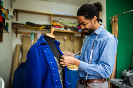 African American men fashion designer,tailor measuring jacket, blazer in his atelier.の写真素材