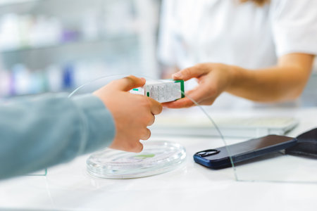 Woman pharmacist  consulting customer at counter for prescription drugs or medicine at the pharmacy. Female doctor giving patient medical antibiotics at the pharmacyの写真素材