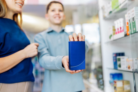 Close up of child holding up a box of medication in the pharmacy.の写真素材
