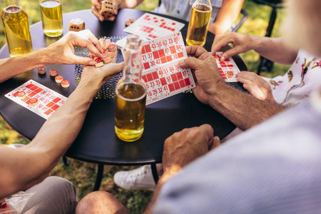 Group of elderly retired people playing bingo outside. Drinking beer and enjoying some time outside.の写真素材