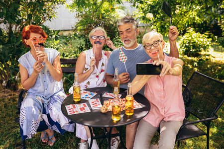 Elderly people are making themselves young again and coming out of their comfort zone using silly glasses, hats, and mustaches.They are also drinking their favourite beverages and making great memoriesの写真素材