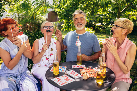 Elderly people are making themselves young again and coming out of their comfort zone using silly glasses, hats, and mustaches.They are also drinking their favourite beverages and making great memoriesの写真素材