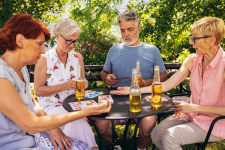 Group of elderly retired people playing bingo outside. Drinking beer and enjoying some time outside.の写真素材