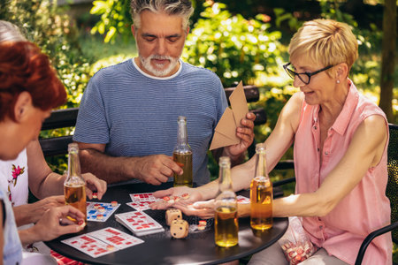 Group of elderly retired people playing bingo outside. Drinking beer and enjoying some time outside.の写真素材