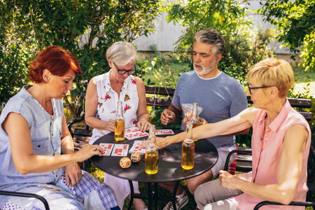 Group of elderly retired people playing bingo outside. Drinking beer and enjoying some time outside.の写真素材