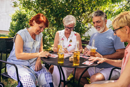 Group of elderly retired people playing bingo outside. Drinking beer and enjoying some time outside.の写真素材