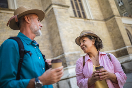 Elderly married couple drinking coffee in the city center. Tourists exploring the city.の写真素材