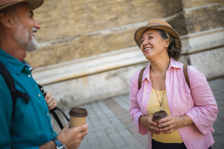 Elderly married couple drinking coffee in the city center. Tourists exploring the city.の写真素材