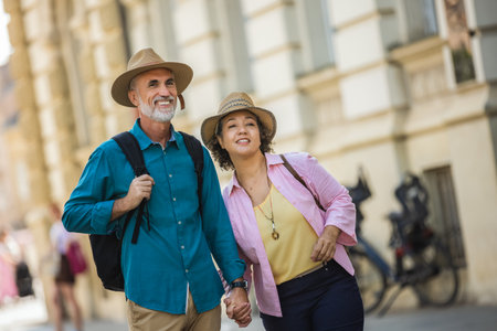 Elderly married couple holding their hands in the city center that they are exploringの写真素材