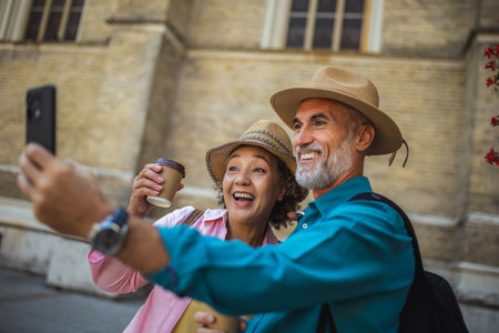 Elderly married couple taking a selfie while on a coffee break. Tourists exploring the new city.の写真素材