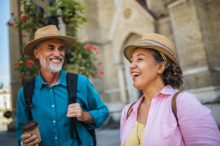 Senior married couple drinking coffee in the city center. Tourists exploring the city.の写真素材