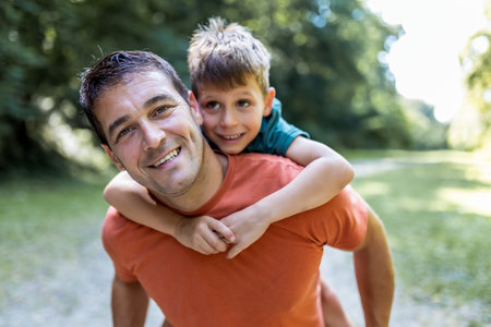 Father playing with his son piggy back.の写真素材
