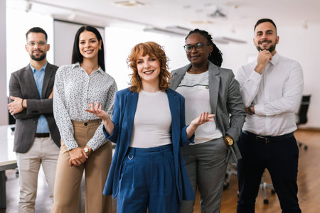 Portrait of young CEO businesswoman standing  with her hands crossed in front of her colleagues.