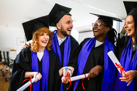 Happy multiracial group of students dressed in togas standing and holding their diplomas.の写真素材