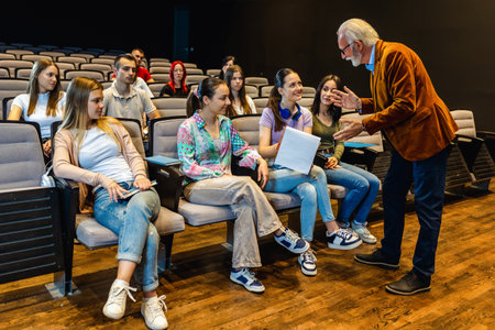 Elderly man professor answering questions from his students in a lecture.の写真素材