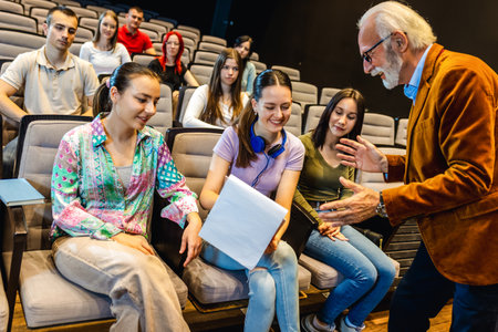 Elderly man professor answering questions from his students in a lecture.の写真素材