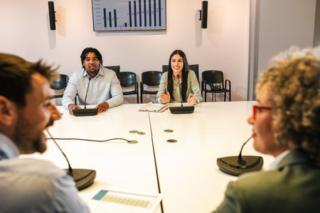 Multiracial group of colleagues talking on the microphone on meeting about business plan, future...