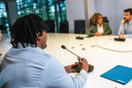 African American man CEO talking on the microphone on meeting with his colleagues about business plan, future collaboration.の写真素材