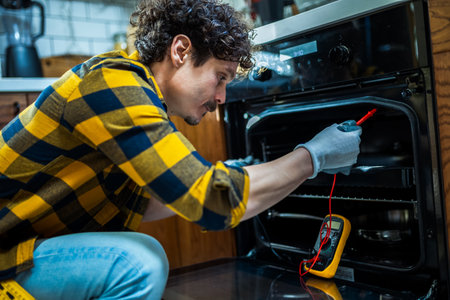 Latino man fixing dishwasher in the kitchen.の写真素材