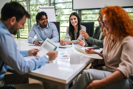 Group of businesspeople having a briefing in a boardroom. Businesspeople working together in a modern workplace. Talking about statistics and graphics in the firm.の写真素材