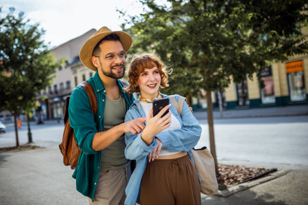 Young couple, on a vacation, exploring the new city and using their phone as gps to help them not get lost.の写真素材