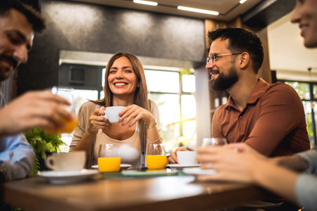 Group of friends laughing together at the coffee shop.の写真素材