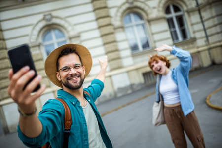 Young couple on a vacation taking selfies in the city center. Travelling and exploring concept.の写真素材