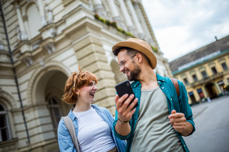 Young couple, on a vacation, exploring the new city and using their phone as gps to help them not get lost.の写真素材