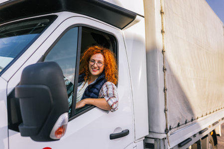 Portrait of professional woman truck driver looking out the window. People and industrial transportation concept.の写真素材