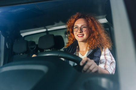 Portrait of a professional ginger woman driving a truck. People and industrial transportation concept.の写真素材