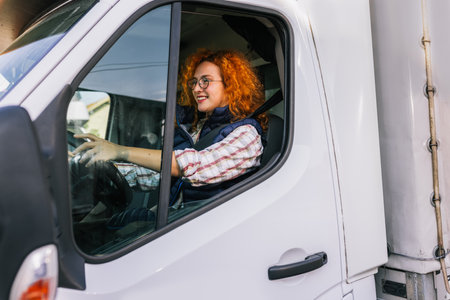 Portrait of a professional ginger woman driving a truck. People and industrial transportation concept.の写真素材