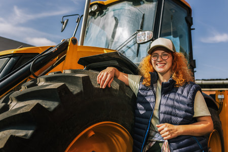 Ginger woman checks the correctness of the excavator.の写真素材