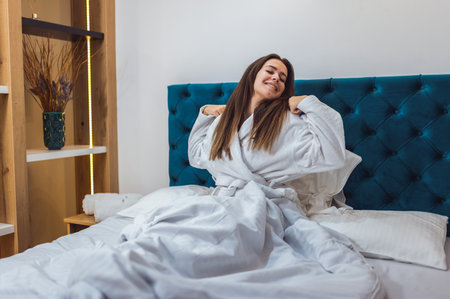 Pretty woman waking up at the hotel room on her vacation.の写真素材