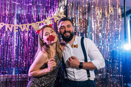 A couple poses at a New Year's party. They have fun with the funny reindeer ears and mouth.の写真素材