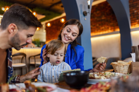 Family of three eating in a restaurant delicious food. Food and drink concept.の写真素材