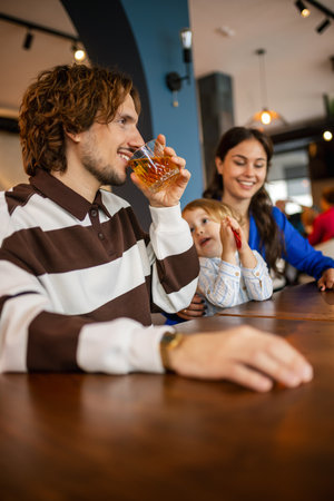 Husband with his wife and child drinking drink in a restaurant.