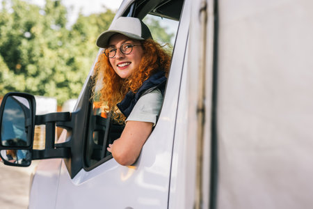 Portrait of professional woman truck driver looking out the window. People and industrial transportation concept.の写真素材
