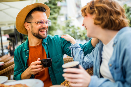 Beautiful couple sits in a restaurant and drinks coffee. Delicious pizza on the table.の写真素材